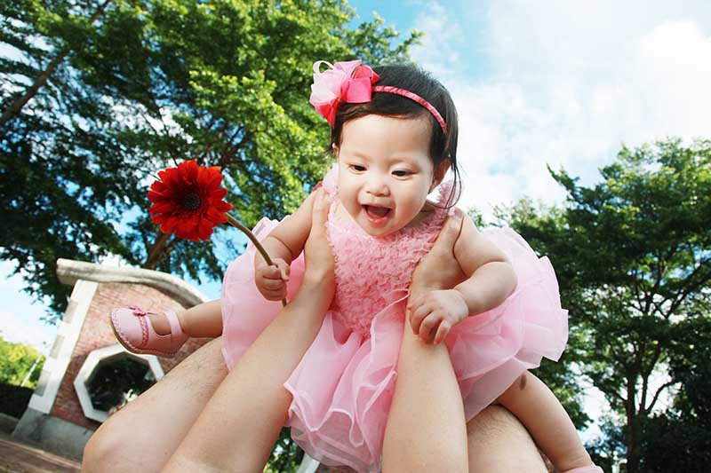 爸比把小女孩抬好高，好像可以飛到很遠的天空